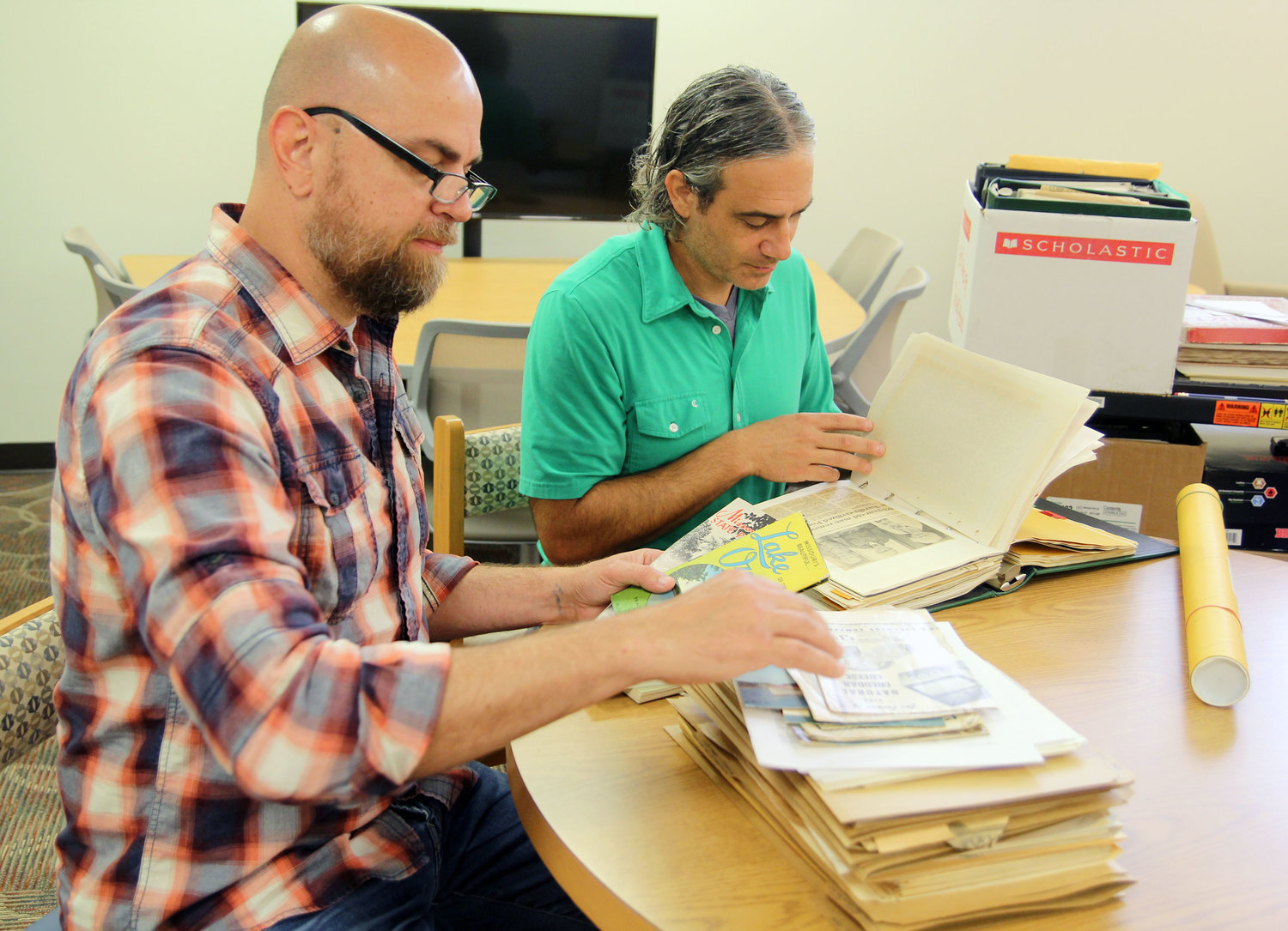 MISSOURI STATE UNIVERSITY-WEST PLAINS (MSU-WP) faculty members Frank Priest, left, and Dr. Jason McCollom look through old brochures and newspaper clippings to determine if they meet the criteria for inclusion in the new Ozarks Heritage Resource Center at the Garnett Library.